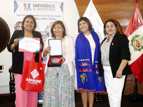Cuatro mujeres posan con un certificado, una placa de reconocimiento y una bolsa de ASMYPE Ayacucho