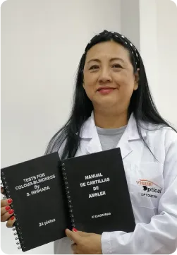 Retrato de Elsa Elías Rodríguez con bata blanca y cartillas de optometría