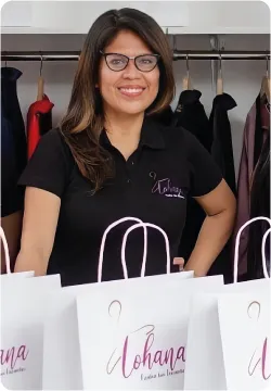 Retrato de Elizabeth Ramirez en su tienda Lohana, con bolsas de la marca